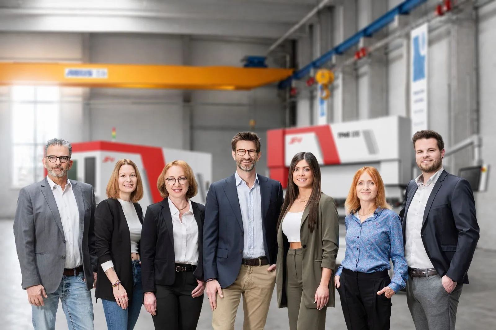 Team von I-H&S vor einer JFY Maschine in der Halle